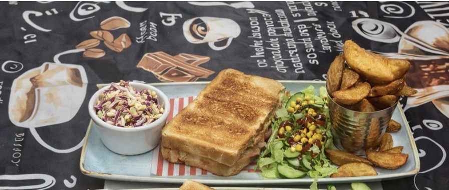 Toasted sandwich served with salad, coleslaw and potato wedges